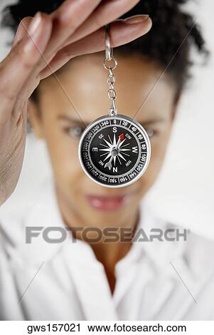 Stock Image - Close-up of a businesswoman holding a compass. Fotosearch