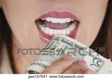 Close-up of a businesswoman holding a bundle of dollar bills near her mouth View Large Photo Image Stock Image - Close-up of a businesswoman holding a bundle of dollar bills near her mouth. Fotosearch
