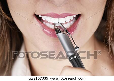 Close-up of a businesswoman smiling with a pen on her lips View Large Photo Image Stock Photography - Close-up of a businesswoman smiling with a pen on her lips. Fotosearch