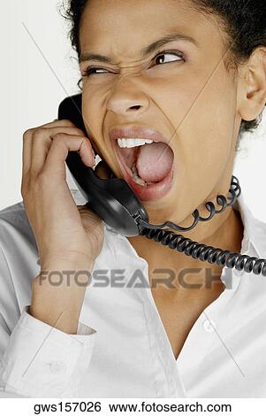 Close-up of a businesswoman talking on telephone and making a face View Large Photo Image Stock Photograph - Close-up of a businesswoman talking on telephone and making a face. Fotosearch
