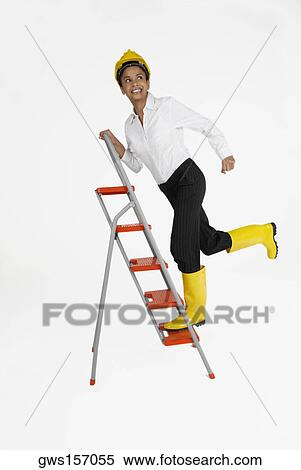 Female architect climbing a ladder and smiling View Large Photo Image Stock Photography - Female architect climbing a ladder and smiling. Fotosearch