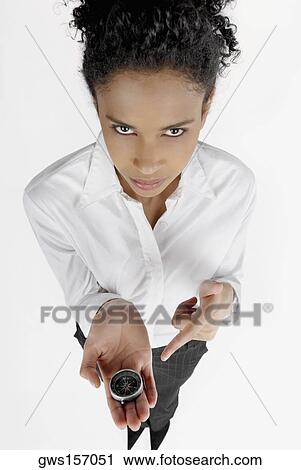 High angle view of a businesswoman pointing at a compass held by her View Large Photo Image Stock Image - High angle view of a businesswoman pointing at a compass held by her. Fotosearch