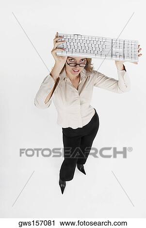 High angle view of a businesswoman holding a computer keyboard over her head View Large Photo Image Stock Image - High angle view of a businesswoman holding a computer keyboard over her head. Fotosearch