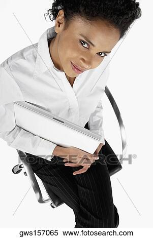 High angle view of a businesswoman sitting on an office chair with a laptop View Large Photo Image Stock Photography - High angle view of a businesswoman sitting on an office chair with a laptop. Fotosearch