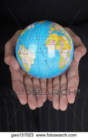 Stock Image - Mid section view of a businesswoman holding a globe. Fotosearch