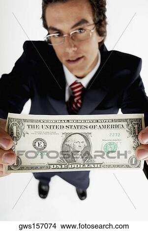 Portrait of a businessman holding an American dollar bill View Large Photo Image Picture - Portrait of a businessman holding an American dollar bill. Fotosearch