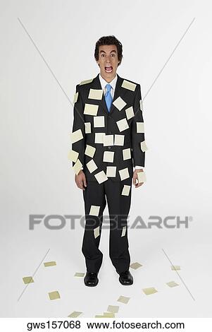 Stock Photo - Portrait of a businessman standing with adhesive notes on his body. Fotosearch