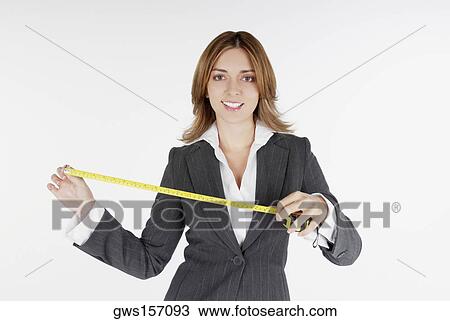 Portrait of a businesswoman holding a measuring tape and smiling View Large Photo Image Stock Image - Portrait of a businesswoman holding a measuring tape and smiling. Fotosearch