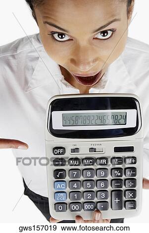 Portrait of a businesswoman holding a calculator with her mouth open View Large Photo Image Stock Photo - Portrait of a businesswoman holding a calculator with her mouth open. Fotosearch