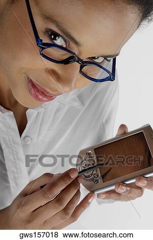 Portrait of a businesswoman operating a hand held device with a digitized pen View Large Photo Image Stock Photo - Portrait of a businesswoman operating a hand held device with a digitized pen. Fotosearch