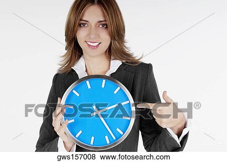 Portrait of a businesswoman pointing at a clock and smiling View Large Photo Image Stock Photo - Portrait of a businesswoman pointing at a clock and smiling. Fotosearch