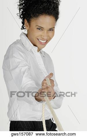 Portrait of a businesswoman pulling a rope and smiling View Large Photo Image Stock Photo - Portrait of a businesswoman pulling a rope and smiling. Fotosearch