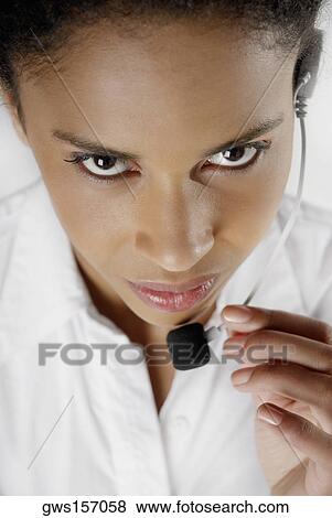 Stock Photo - Portrait of a female customer service representative talking on a headset. Fotosearch