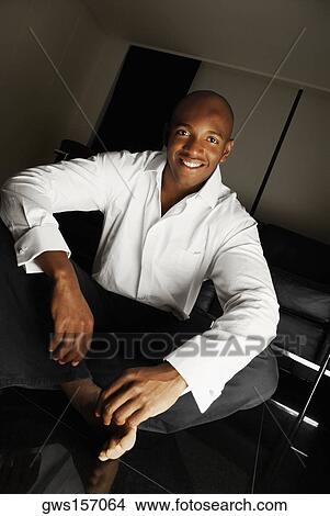 Portrait of a young man sitting on the floor and smiling View Large Photo Image Picture - Portrait of a young man sitting on the floor and smiling. Fotosearch