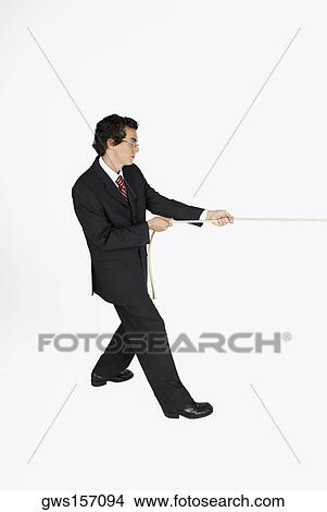 Side profile of a businessman pulling a rope View Large Photo Image Picture - Side profile of a businessman pulling a rope. Fotosearch