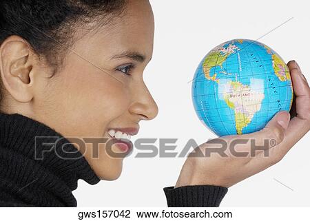 Side profile of a businesswoman holding a globe and smiling View Large Photo Image Stock Image - Side profile of a businesswoman holding a globe and smiling. Fotosearch
