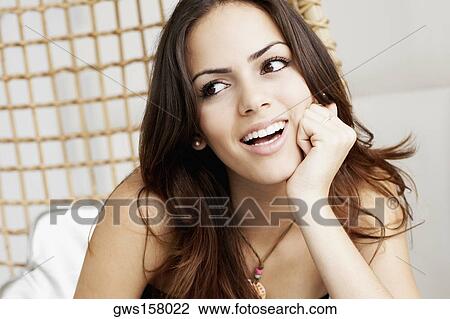 Close-up of a young woman with her hand on her chin View Large Photo Image Stock Image - Close-up of a young woman with her hand on her chin. Fotosearch