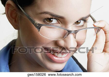 Portrait of a businesswoman peeking over her eyeglasses and smiling View Large Photo Image Stock Photograph - Portrait of a businesswoman peeking over her eyeglasses and smiling. Fotosearch