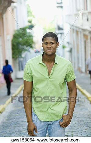 Portrait of a young man standing on the street View Large Photo Image Picture - Portrait of a young man standing on the street. Fotosearch