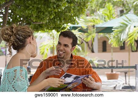 Stock Image - Close-up of a teenage girl and a mid adult man holding a menu in a restaurant. Fotosearch