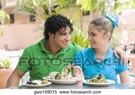 Close-up of a young man and a teenage girl sitting at a table in a restaurant View Large Photo Image Stock Photography - Close-up of a young man and a teenage girl sitting at a table in a restaurant. Fotosearch