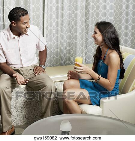 Close-up of a young woman holding a glass of orange juice with a young man beside her View Large Photo Image Stock Image - Close-up of a young woman holding a glass of orange juice with a young man beside her. Fotosearch