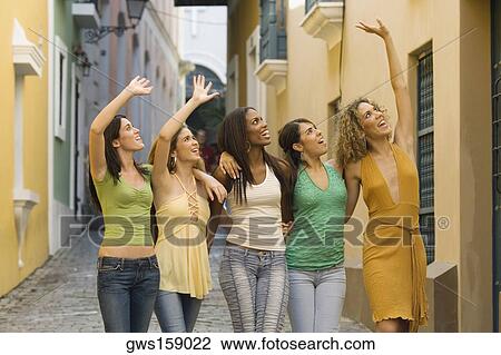 Stock Image - Five teenage girls standing together and waving. Fotosearch