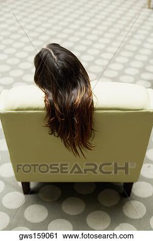 High angle view of a woman sitting on a chair View Large Photo Image Stock Image - High angle view of a woman sitting on a chair. Fotosearch