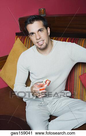 Portrait of a mid adult man sitting on a couch and holding a cocktail View Large Photo Image Stock Image - Portrait of a mid adult man sitting on a couch and holding a cocktail. Fotosearch