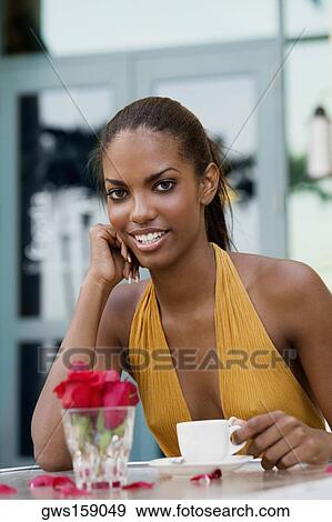Stock Photo - Portrait of a teenage girl sitting at a restaurant with a cup of coffee . Fotosearch