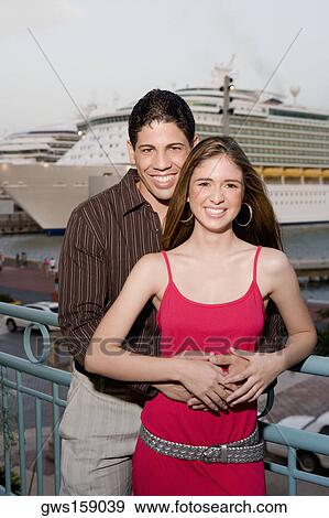 Portrait of a young man embracing a teenage girl from behind View Large Photo Image Stock Photo - Portrait of a young man embracing a teenage girl from behind. Fotosearch