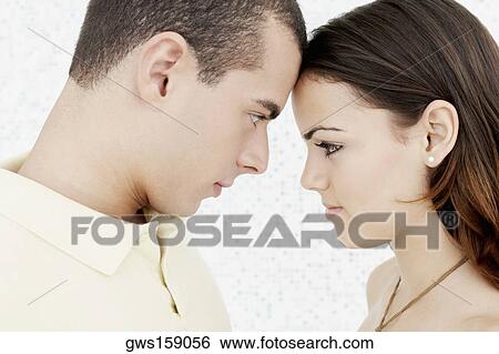 Side profile of a young couple face to face View Large Photo Image Stock Photograph - Side profile of a young couple face to face. Fotosearch