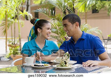 Young man and a teenage girl sitting in a restaurant and smiling View Large Photo Image Stock Image - Young man and a teenage girl sitting in a restaurant and smiling. Fotosearch
