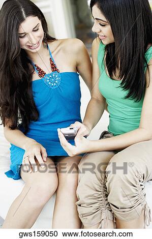 Young woman and teenage girl looking at a mobile phone View Large Photo Image Stock Image - Young woman and teenage girl looking at a mobile phone. Fotosearch
