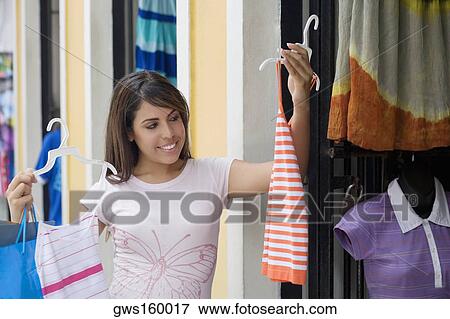 Stock Photo - Close-up of a teenage girl choosing a tank top. Fotosearch