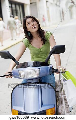 Close-up of a teenage girl riding a scooter View Large Photo Image Stock Photo - Close-up of a teenage girl riding a scooter. Fotosearch