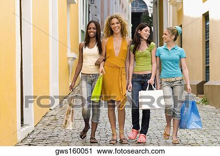 Four teenage girls walking in an alley and holding shopping bags View Large Photo Image Stock Image - Four teenage girls walking in an alley and holding shopping bags. Fotosearch