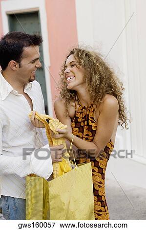 Mid adult man and a teenage girl holding a shopping bag and smiling View Large Photo Image Stock Photo - Mid adult man and a teenage girl holding a shopping bag and smiling. Fotosearch
