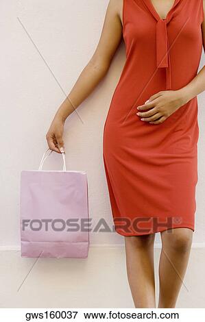 Mid section view of a teenage girl holding a shopping bag View Large Photo Image Stock Photo - Mid section view of a teenage girl holding a shopping bag. Fotosearch