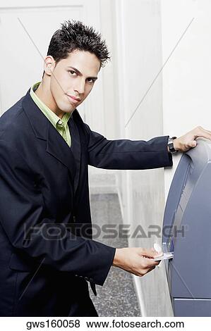 Portrait of a businessman inserting a credit card into an ATM View Large Photo Image Stock Photo - Portrait of a businessman inserting a credit card into an ATM. Fotosearch
