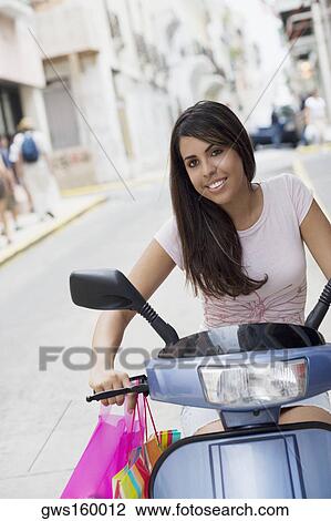 Stock Image - Portrait of a teenage girl riding on a motor scooter. Fotosearch