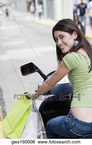 Portrait of a teenage girl riding on a scooter View Large Photo Image Stock Photo - Portrait of a teenage girl riding on a scooter. Fotosearch
