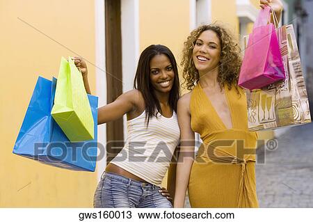 Portrait of two teenage girls holding shopping bags and smiling View Large Photo Image Stock Image - Portrait of two teenage girls holding shopping bags and smiling. Fotosearch