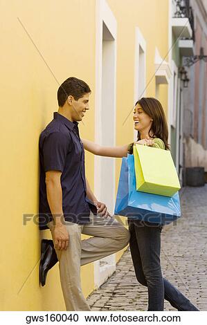 Side profile of a teenage girl holding shopping bags and standing with a young man View Large Photo Image Stock Image - Side profile of a teenage girl holding shopping bags and standing with a young man. Fotosearch