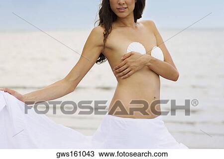 Close-up of a young woman standing on the beach View Large Photo Image Stock Image - Close-up of a young woman standing on the beach. Fotosearch