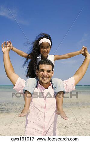Portrait of a mid adult man carrying his daughter on his shoulders View Large Photo Image Stock Photo - Portrait of a mid adult man carrying his daughter on his shoulders. Fotosearch
