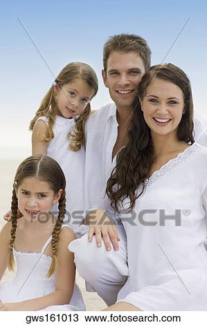 Portrait of a young couple and their two daughters smiling View Large Photo Image Stock Image - Portrait of a young couple and their two daughters smiling. Fotosearch