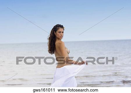 Portrait of a young woman standing on the beach View Large Photo Image Stock Image - Portrait of a young woman standing on the beach. Fotosearch