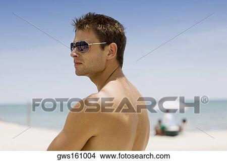 Side profile of a young man wearing a pair of sunglasses View Large Photo Image Picture - Side profile of a young man wearing a pair of sunglasses. Fotosearch