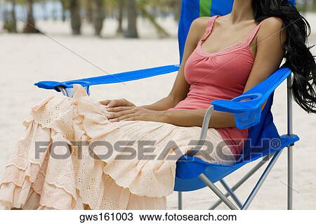 Young woman sitting on a folding chair View Large Photo Image Stock Image - Young woman sitting on a folding chair. Fotosearch